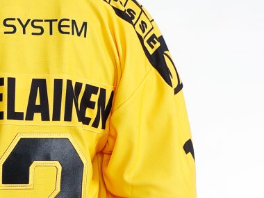 KalPan pelipaidan selkämys, jossa OC-Systemin logo ja pelaajatunnus SAARELAINEN 12