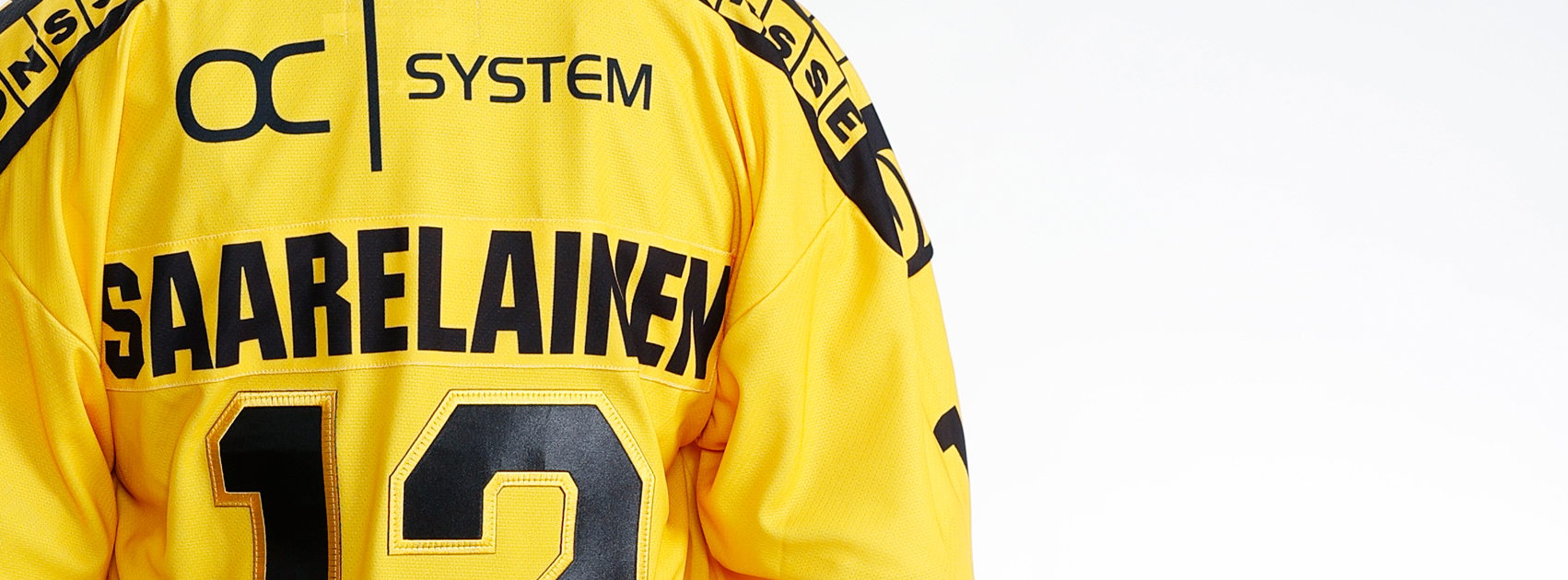 KalPan pelipaidan selkämys, jossa OC-Systemin logo ja pelaajatunnus SAARELAINEN 12